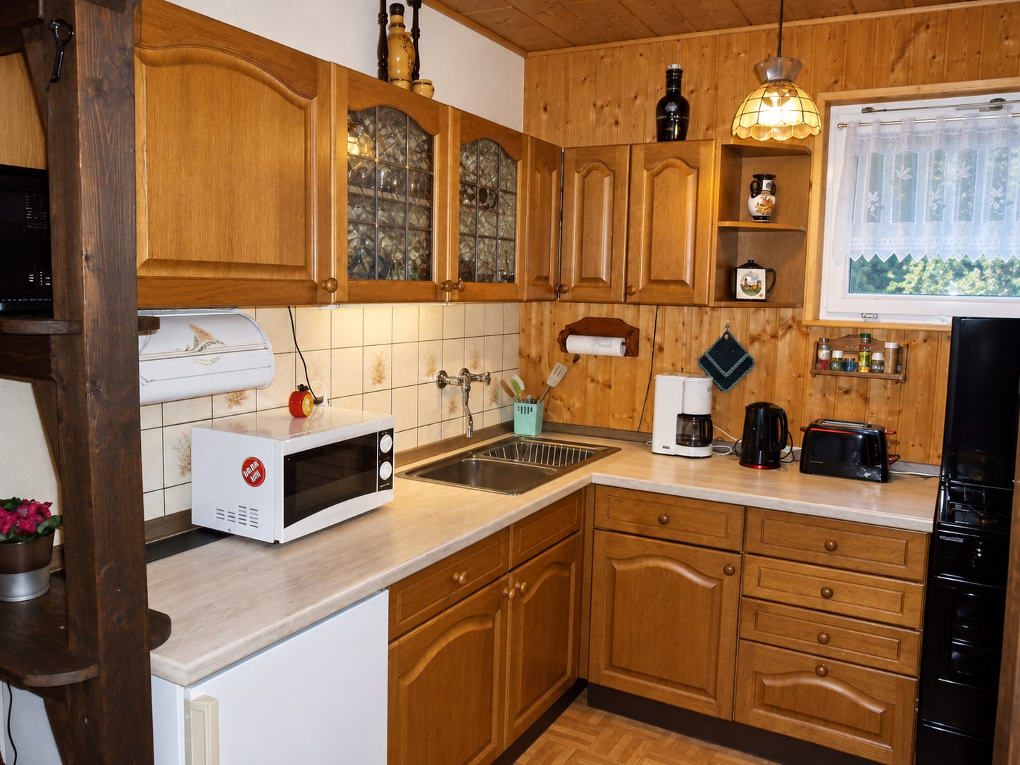 Küchenzeile im Bungalow mit Herd, Mikrowelle, Kaffeemaschine und Toaster