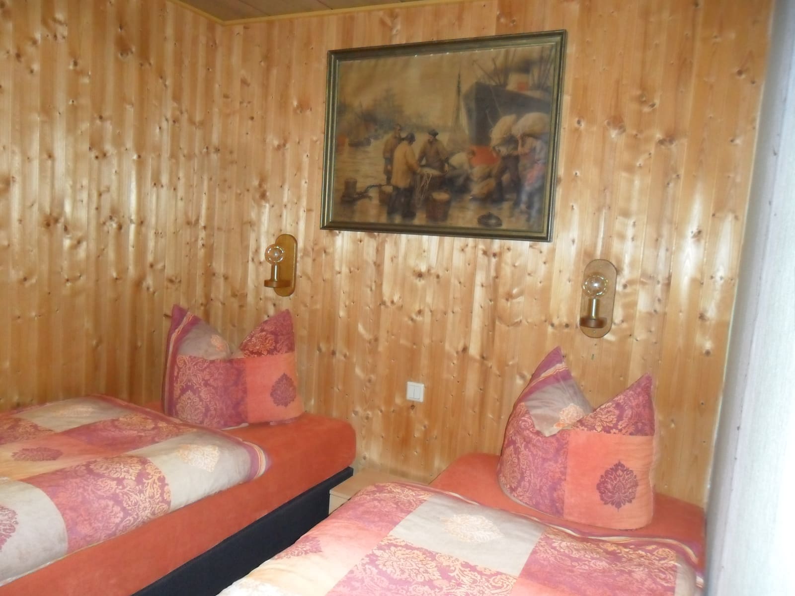Schlafzimmer im Bungalow mit zwei Einzelbetten vor holzvertäfelter Wand