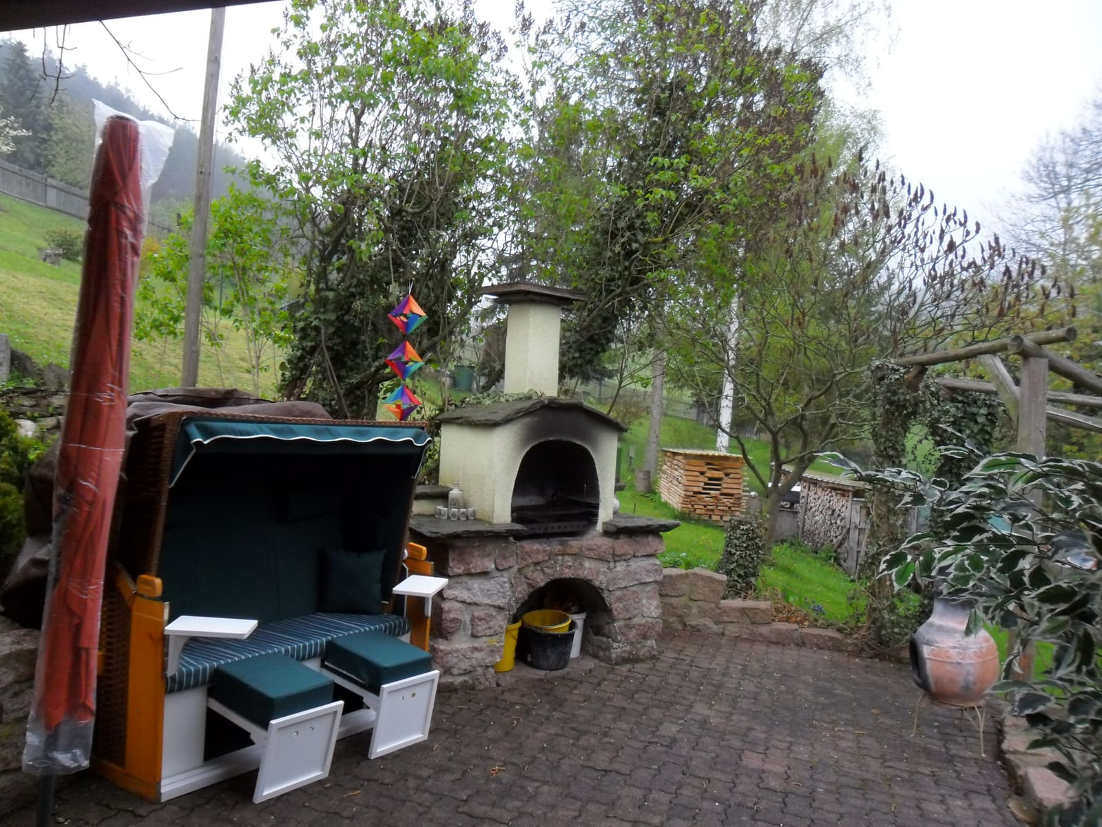 Freisitz mit Strandkorb und gemauertem Grillkamin mit Backofen auf gepflastertem Grund
