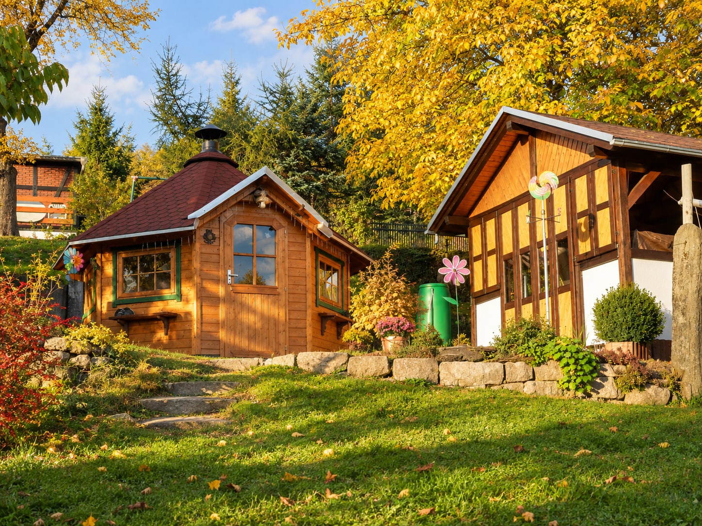 Grillkota und Gartenhaus im goldenen Herbstlicht auf der Wiese hinter dem Haus
