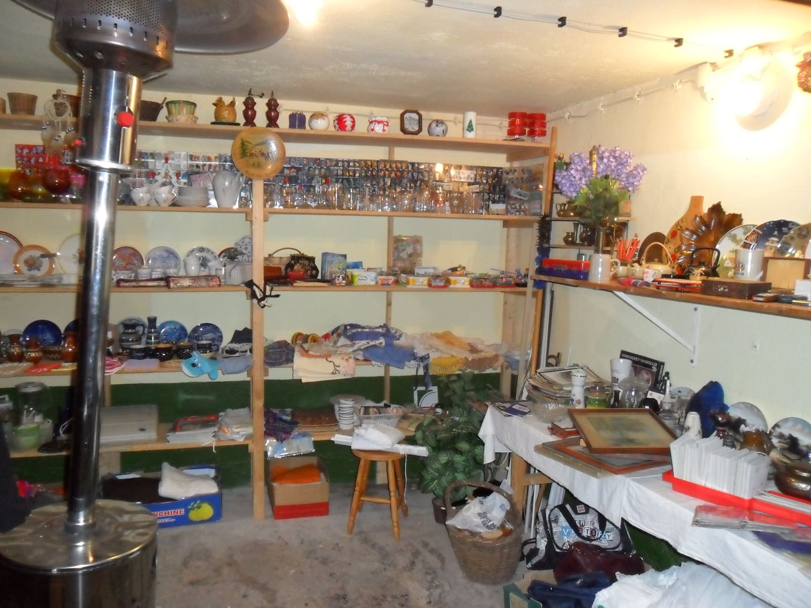Der kleine Trödelmarkt im Haus mit Regalen voller Geschirr, Gläser und Fundstücke