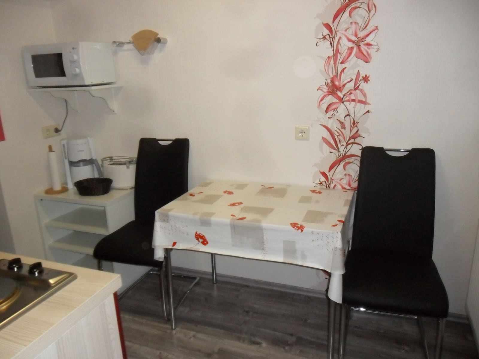 Essplatz der Single-Wohnung mit Küchenzeile, Mikrowelle und Wasserkocher